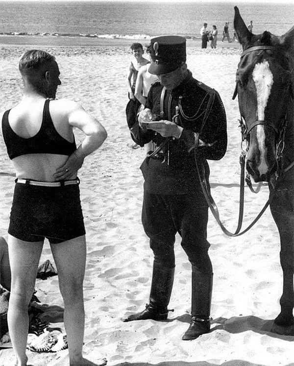 12. Plajda bir adam uygun mayo giymediği için para cezasına çarptırılıyor.
