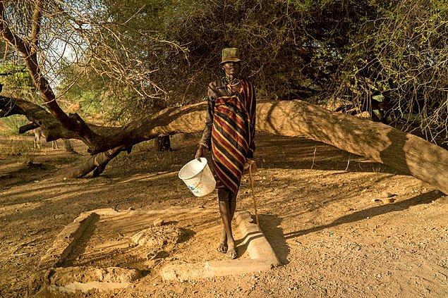 İklim değişikliği yüzünden susuzluk çekilen Kenya'da su dağıtımı için sıra bekleyen kadın.