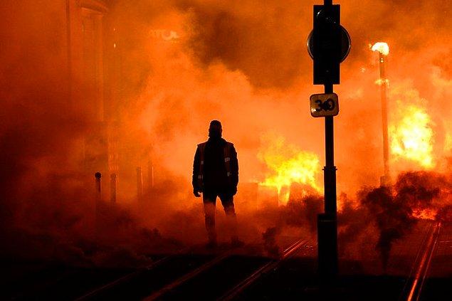 Fransa'da hükûmet karşıtı yapılan protesto sonucunda çıkan yangın ve bir itfaiyeci.
