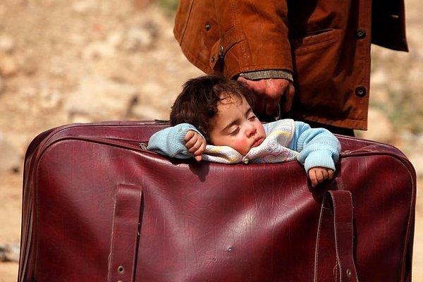 1. Mültecilerin yaşadığı acıları özetleyen bir kare: Çantasına koyduğu çocuğu ile umudun peşinde bir baba