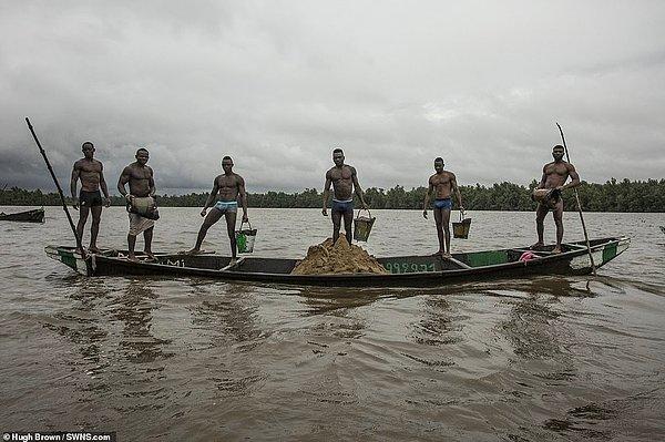 Afrika'da Kamerunlu bir kabilenin işçileri her gün Wouri Nehri'nin dibine dalıp ıslak kum çıkartarak geçimlerini sağlıyorlar.