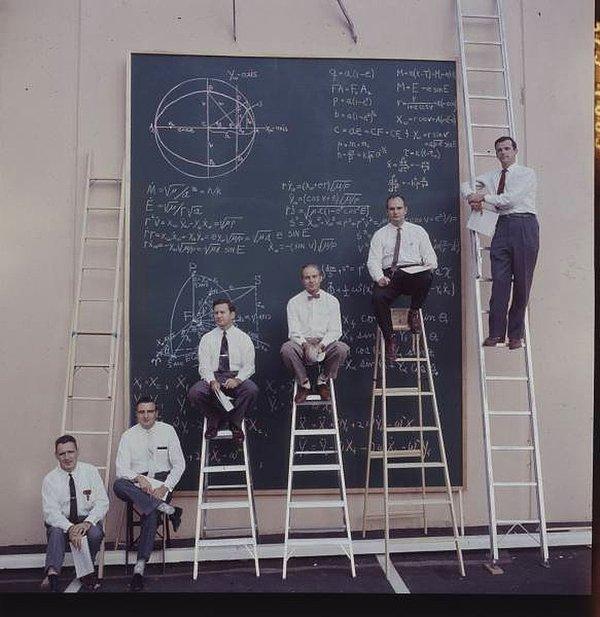 9. NASA bilim insanları hesaplamalar yaptıkları tahtanın önünde poz veriyorlar.