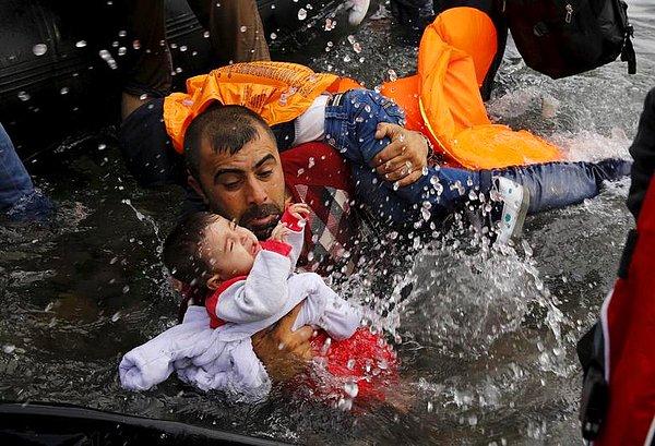 Behrakis'e Pulitzer ödülünü kazandıran fotoğraf: 24 Eylül 2015, Yunanistan'ın Midilli adasında çocuğunu korumaya çalışan mülteci baba.
