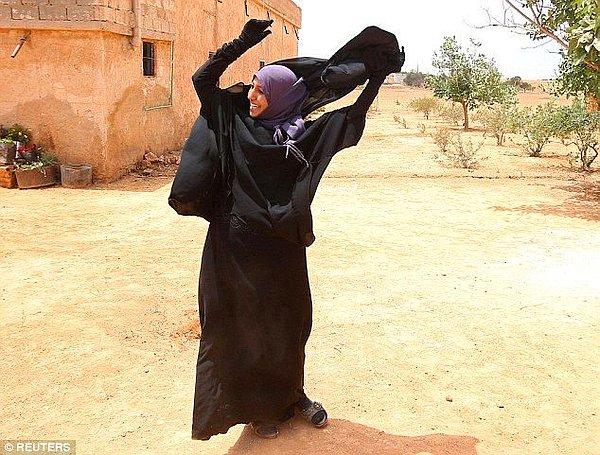 8. Şehri IŞİD'in elinden kurtarılan kadın peçesini çıkarıyor.