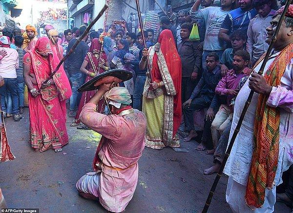 Barsana kasabası yakınlarında bir kadın sopayla kocasını dövüyor. Bu gelenek genellikle etkinlikten birkaç gün önce uygulanıyor.