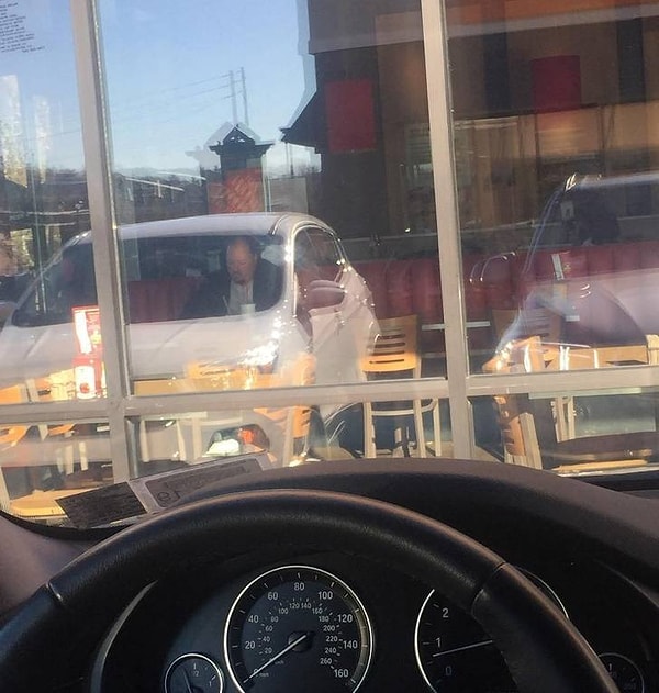 35. Этот мужчина словно сидит в припаркованной рядом машине, а на самом деле он просто наслаждается своим бургером в закусочной :).