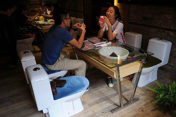 Banyo lavabosunun üzerine cam konarak dizayn edilmiş masalardan yiyip; gerçek bir tuvalette oturarak sohbet edeceksiniz.