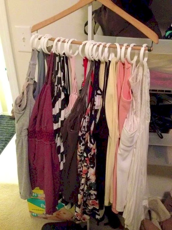 20. Чтобы сэкономить место в шкафу, можно купить кольца для душа и вешать на них майки и футболки вот таким образом: