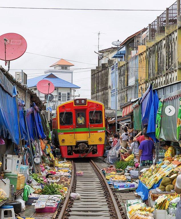 2. Tayland, Bangkok'taki Maeklong Demiryolu Pazarı doğrudan tren raylarına kurulur ve tren tezgahların arasından geçer.
