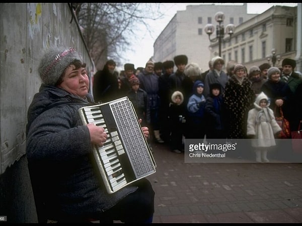 10. Женщина играет на аккордеоне на Арбате, привлекая туристов.