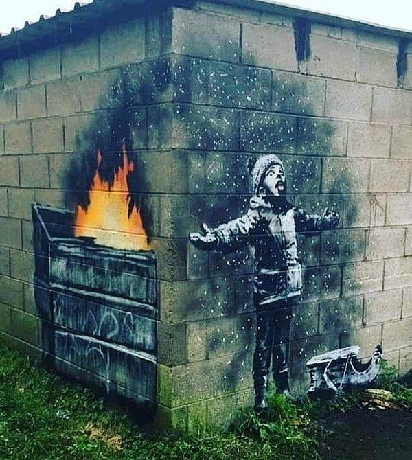 İşte yeni bir Banksy eseri. Külleri fark etmeden önce çocuğun kar taneleri yakalamaya çalıştığını düşünüyorsun.