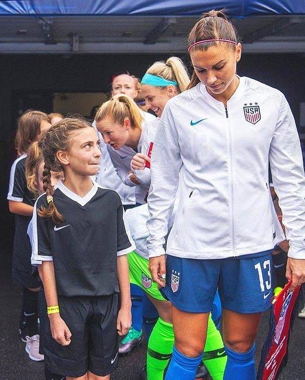Hayran olduğu futbolcuyla yan yana olan küçük kız.