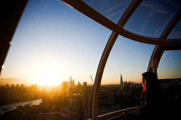 4. Bir kadın London Eye'ın en yüksek noktasından gün doğumunu izlemekte.