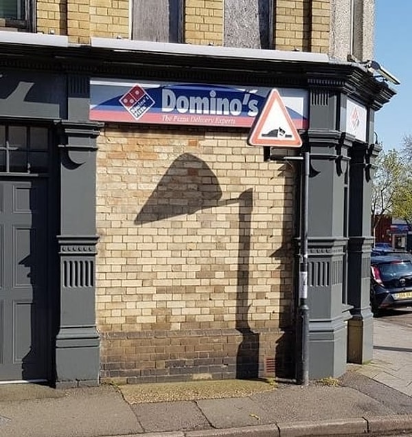 10. Как вам такой кусочек пиццы возле вывески пиццерии?