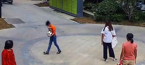 Çin'in Jiangsu eyaletinde meydana gelen olayda, sokakta arkadaşlarıyla oyun oynayan 11 yaşındaki çocuğun vurduğu top, elektrikli bisikletle oradan geçmekte olan bir kadının koluna geldi.