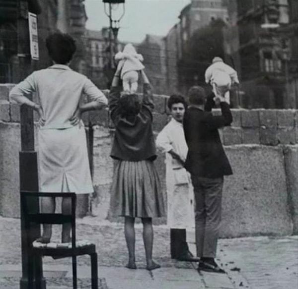 14. Batı Berlin sakinleri, bebeklerini Doğu yakasında yaşayan akrabalarına gösteriyor, 1961.