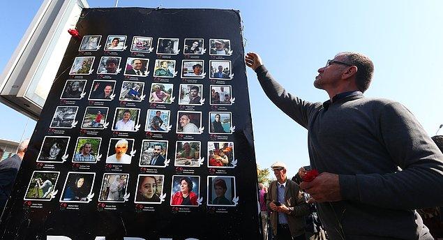 Katılımcılar, terör saldırısında yaşamını yitirenlerin fotoğraflarının olduğu pankart açtı.