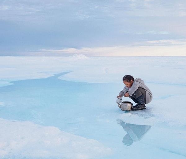 61. Acacia Johnson'ın Kanada'da çektiği bu fotoğrafta küçük kız denizin donmasıyla yüzeye çıkan tatlı suyu topluyor.