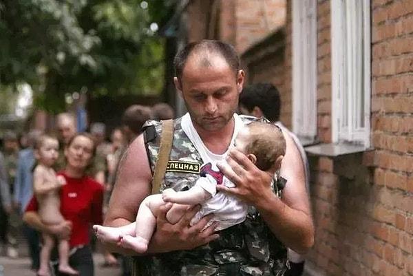 29. Çeçenistan yakınlarındaki Kuzey Ossentia'da 2004 yılında silahlı insanların bir okulu rehin almasının ardından bir Rus polisi salınan bebeği taşıyor.