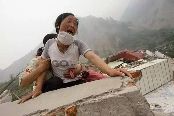 31. 2008'de Çin'i vuran depremin ardından 4 yaşındaki kızını ve eşini bulamayan kadın, bir okulun harabelerinin üzerinde ağlıyor.