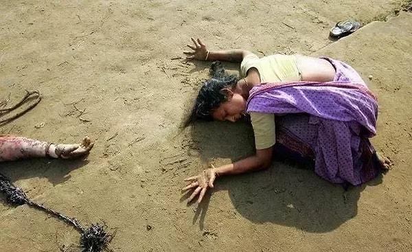 36. 28 Aralık 2004'te çekilen bu fotoğrafta, Hindistanlı kadın tsunamide ölen akrabasının bedeni başında ağlıyor.