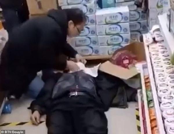 Zhengzhou şehrinde bir süper markette kaydedilen görüntülerde, 80'li yaşlarında olduğu belirtilen bir kişi yerde yatıyor.
