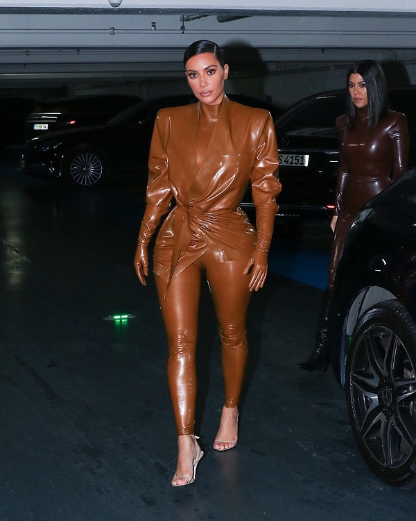 Ее старшая сестра, Кортни, тоже предстала в комбинезоне Balmain, выбрав шоколадный оттенок и черные высокие сапоги на низком каблуке