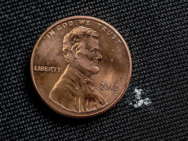 6. Bir Amerikan demir parası ve ölümcül miktarda fentanil maddesi yan yana.