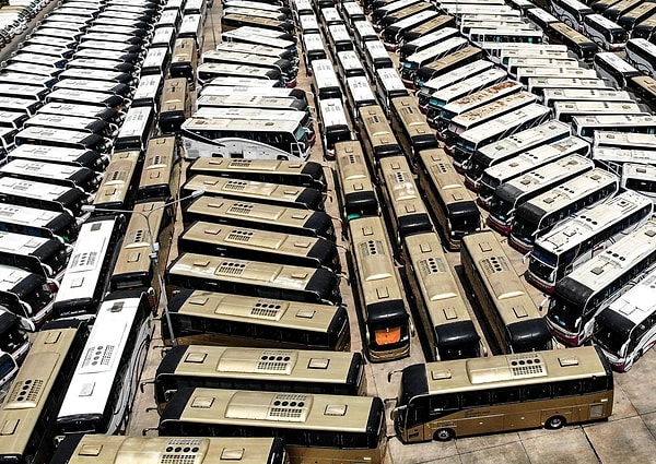 Аэрофотосъемка показывает неиспользуемые туристические автобусы на стоянке около аэропорта Суварнабхуми в Бангкоке, Таиланд, 8 марта 2020 года. Ряды туристических автобусов простаивают под палящим солнцем, в то время как некогда шумные тематические парки пустуют из- за опасений нового коронавируса.