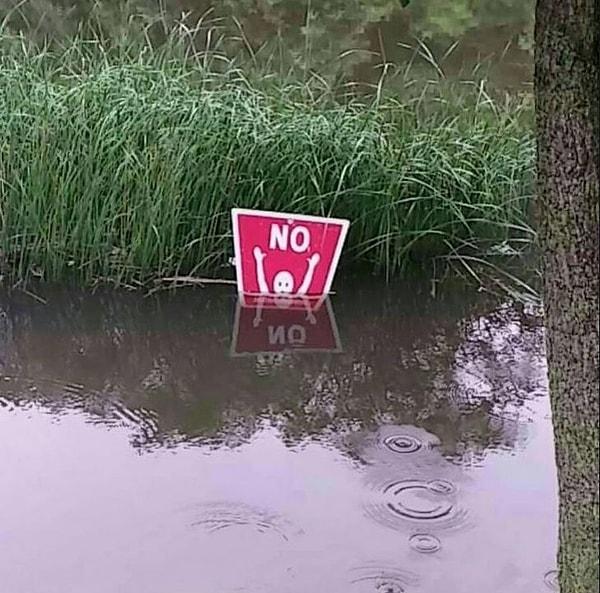 14. Yağan yağmurdan dolayı 'Yüzmek Yasaktır' tabelasının sular altında kalması.