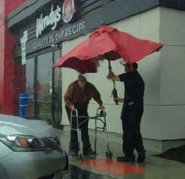 15. Bu süpermarket çalışanı ise arabasına gitmeye çalışan bu yaşlı adamı yağmurdan korumaya çalışıyor...😭
