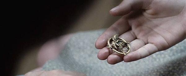 1. 'Açlık Oyunları'nda, Madge'in Katniss'e alaycı kuş iğnesini verdiği an.