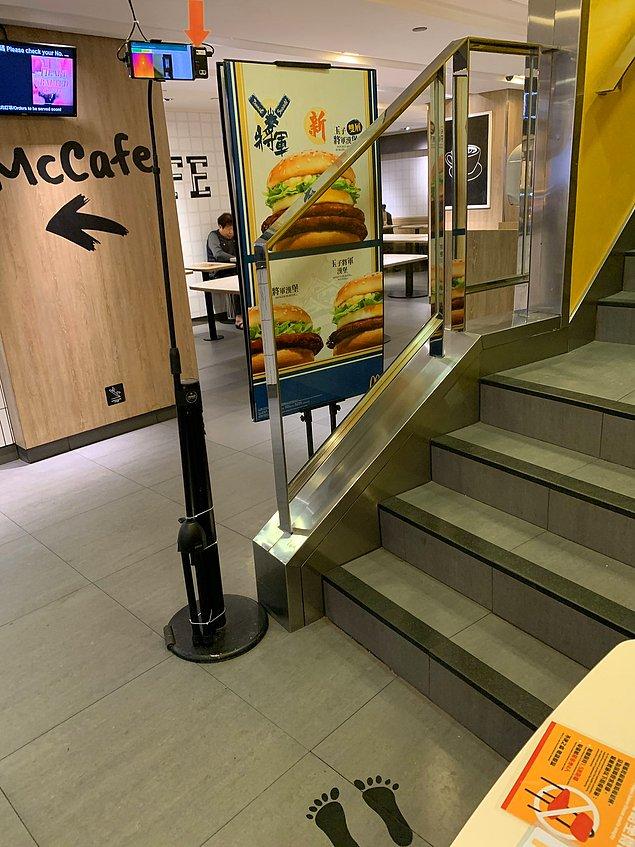 13. Yine HongKong'da bulunan başka bir McDonalds'da müşteriler içeri alınmadan ateşleri ölçülüyor.