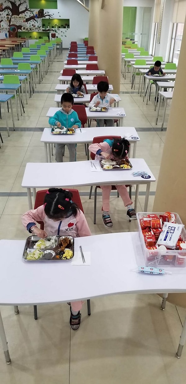 Henry'nin paylaştığı en çarpıcı fotoğraflardan biri de ayrı masalarda öğle yemeği yiyen öğrenciler:
