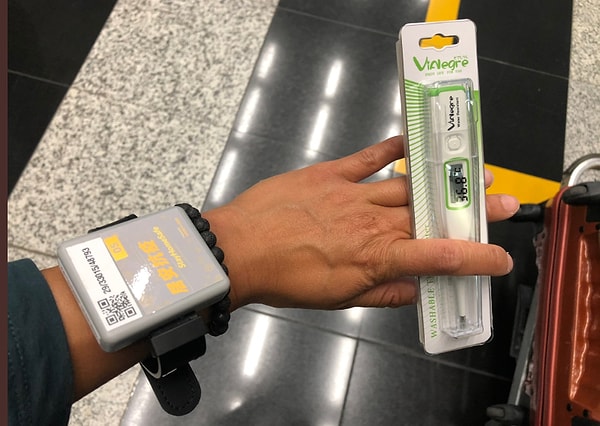 "После того, как я получил свой браслет и градусник, я прошла визовую проверку и взяла свой багаж. С другой стороны, нас направили в автобусы, и наш багаж был помещен молодыми людьми, одетыми в защитные костюмы."