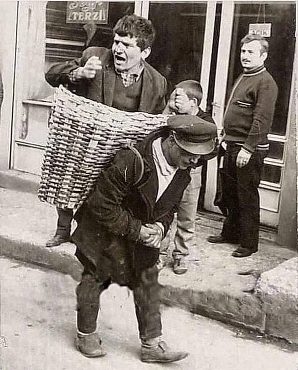 13. Пьяный мужчина в корзине. Бары в Турции нанимали разносчика, работа которого состояла в том, чтобы отнести мужчин домой, которые были слишком пьяны, чтобы встать. Стамбул 1960-х годов.