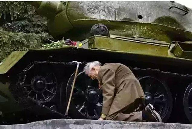 3. İkinci Dünya Savaşı'nda savaşan eski askerlerden biri, savaşı içinde geçirdiği tankın önünde eğiliyor.