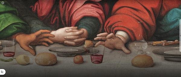 İhanetini simgeleyen keseyi sağ elinde tutan Judas sol eliyle de İsa ile aynı tabaktan yemek yiyor.