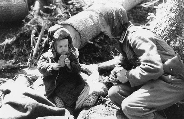 3. Alışık olmadığımız bir görüntü: Alman askeri, öksüz kalan Rus çocuğuna yiyecek veriyor.