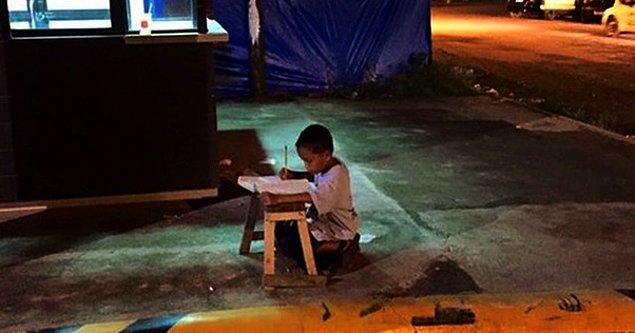11. Filipinli Daniel, sokakta yaşadığı için ödevini restorandan gelen ışığın altında yapıyor.