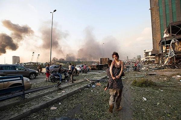 15. Beyrut'ta yaşanan patlamanın ardından, kucakta taşınmak durumunda kalan kız.