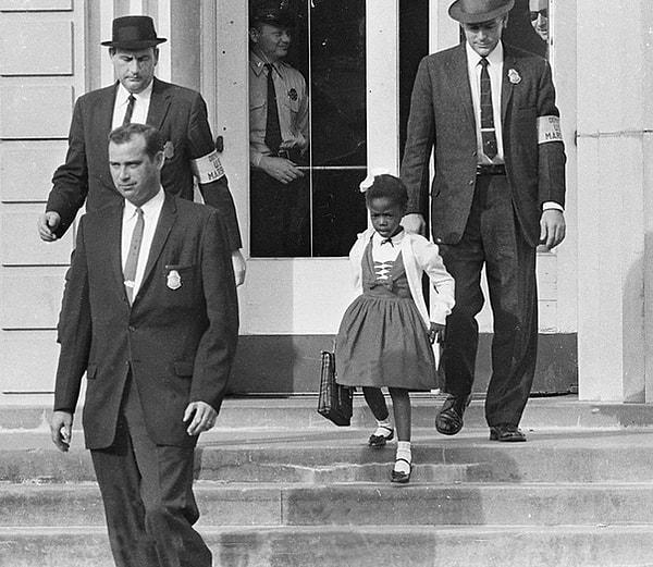 4. Karma eğitime geçilmesiyle beyazlarla okula giden ilk siyahi çocuk Ruby Bridges ve kolluk kuvvetleri.
