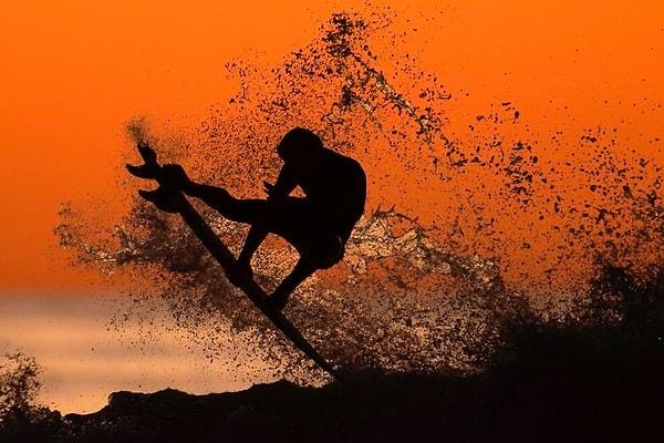 17. Kaliforniya'da gün batımında sörf yapan bir sörfçü.
