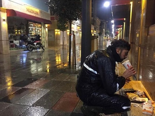 5. Kafe ve restoranlarda yemek yemek yasak olduğu için yağmur altında karnını doyurmaya çalışan kuryenin bu fotoğrafı herkesi isyan ettirdi.