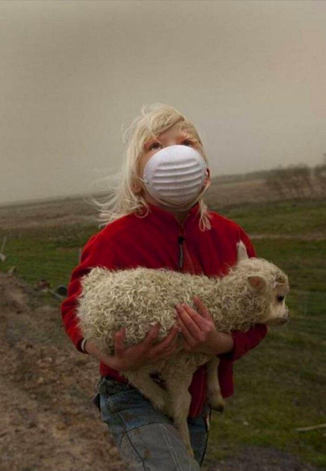 14. Volkan patlaması yüzünden zarar görmemek için lambayı maske olarak kullanan küçük kız.