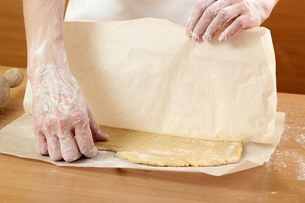 8. Eğer yapacağınız kurabiyenin hamurunu önce açıp sonra şekillendirecekseniz, mutfak tezgahında açmak yerine iki yağlı kağıt arasında açarak işinizi kolaylaştırabilirsiniz.