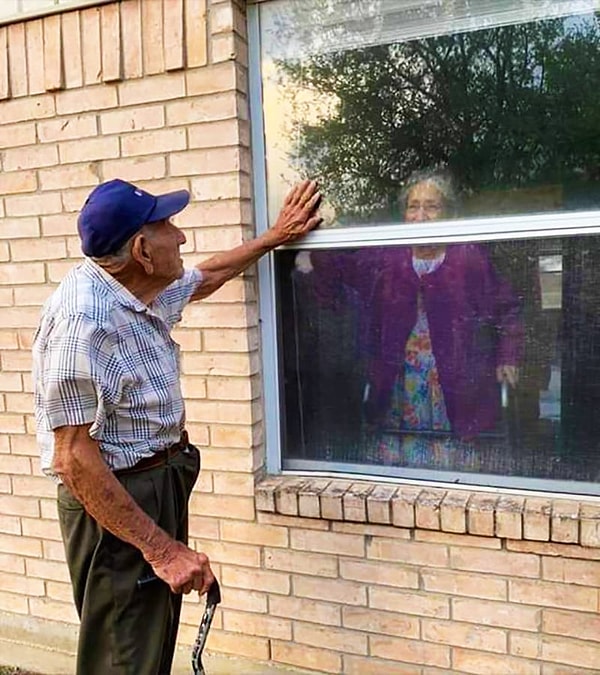 8. Пожилая пара из города Флоресвилл, Техас, видятся через окно в доме престарелых