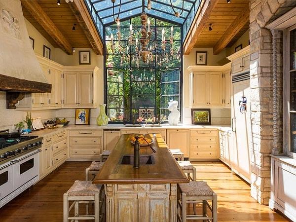 Doğal ışığın bolca girebildiği, tavana kadar uzanan pencerelere sahip bir mutfağı var.