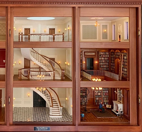 Многоуровневое фойе и библиотека, отделанная деревянными панелями.