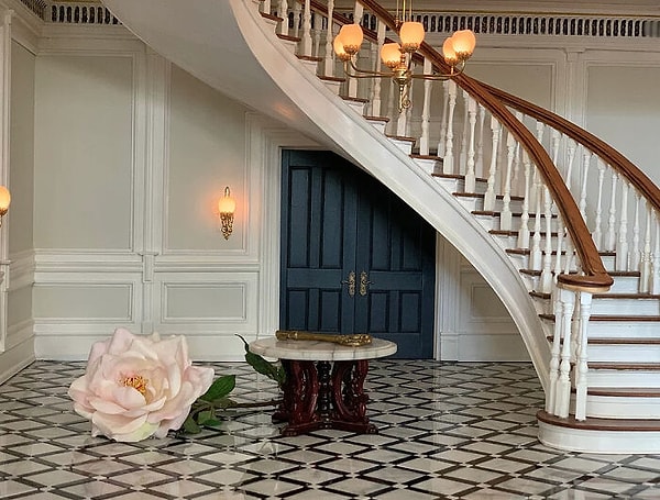 Трехэтажное парадное фойе на первом этаже с круглой лестницей и двустворчатыми дверями